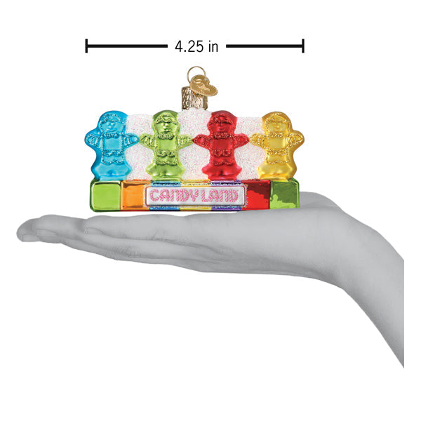 Colorful candy-themed ornament resembling gummy bears on a 'Candy Land' box, held in a hand for scale.