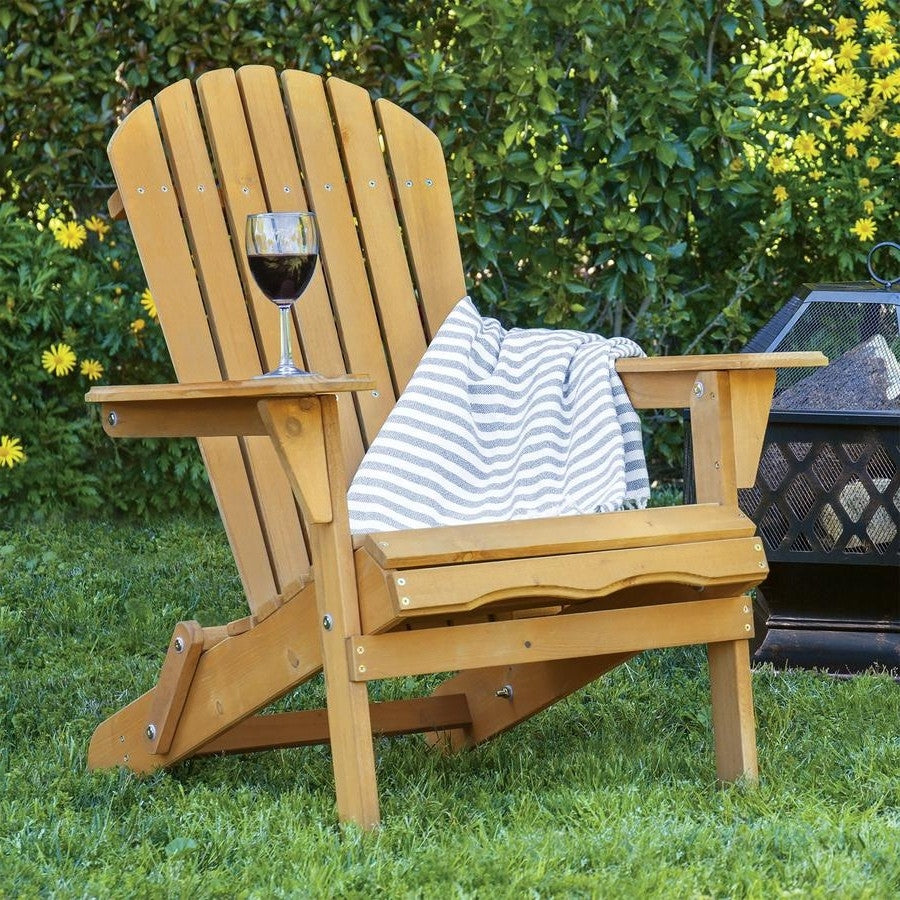 All Weather Adirondack Large Foldable Chair Natural Finish with wine glass and blanket in a garden setting.