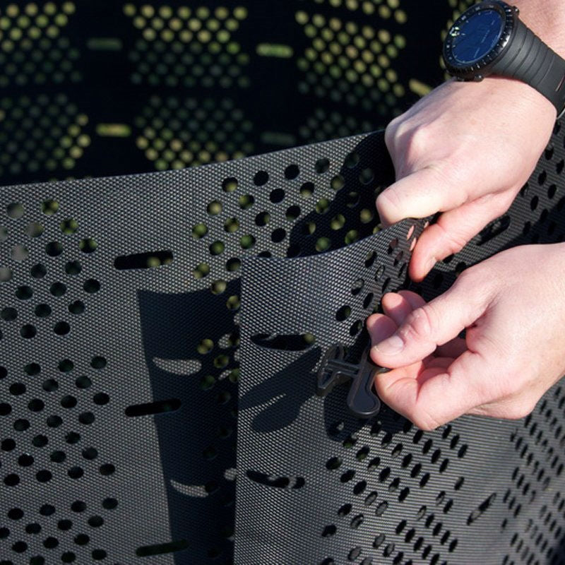 Person adjusting a black strap on a textured surface