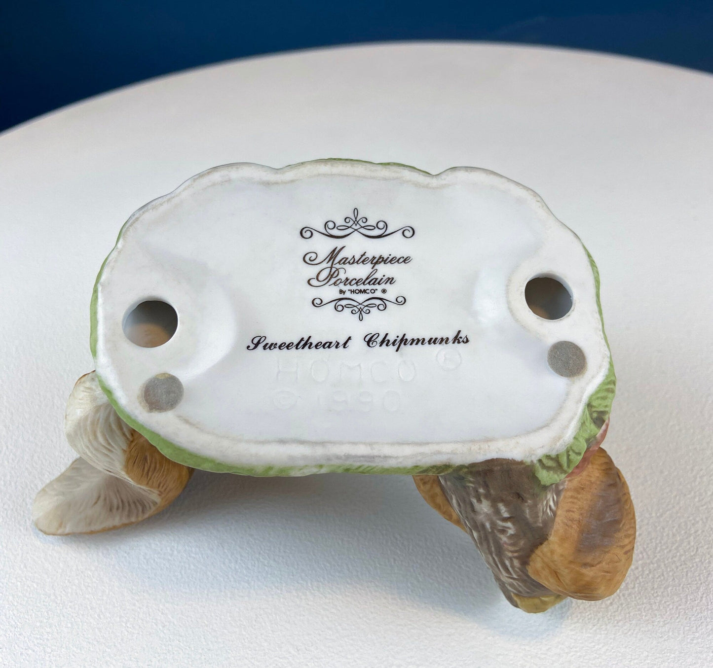 Ceramic squirrel figurine with 'Masterpiece Porcelain' branding on a white background