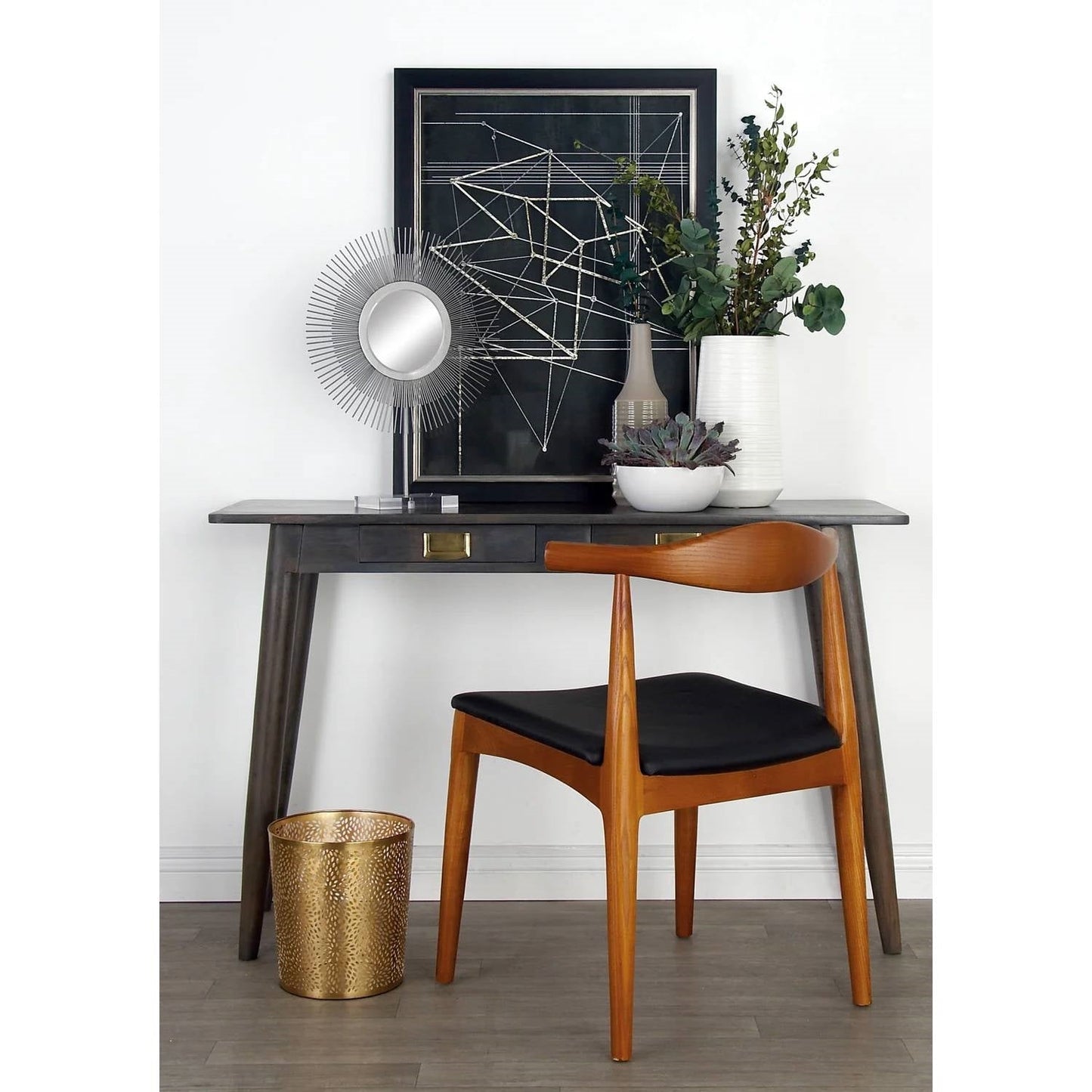 Wooden chair with black cushion in front of a wooden desk with decorative items.