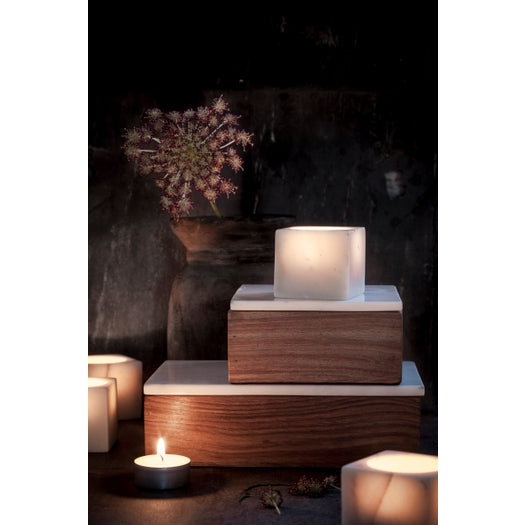 Maeve Wood and Marble Box displayed with candles and flowers in a dimly lit setting, showcasing its minimalist design.