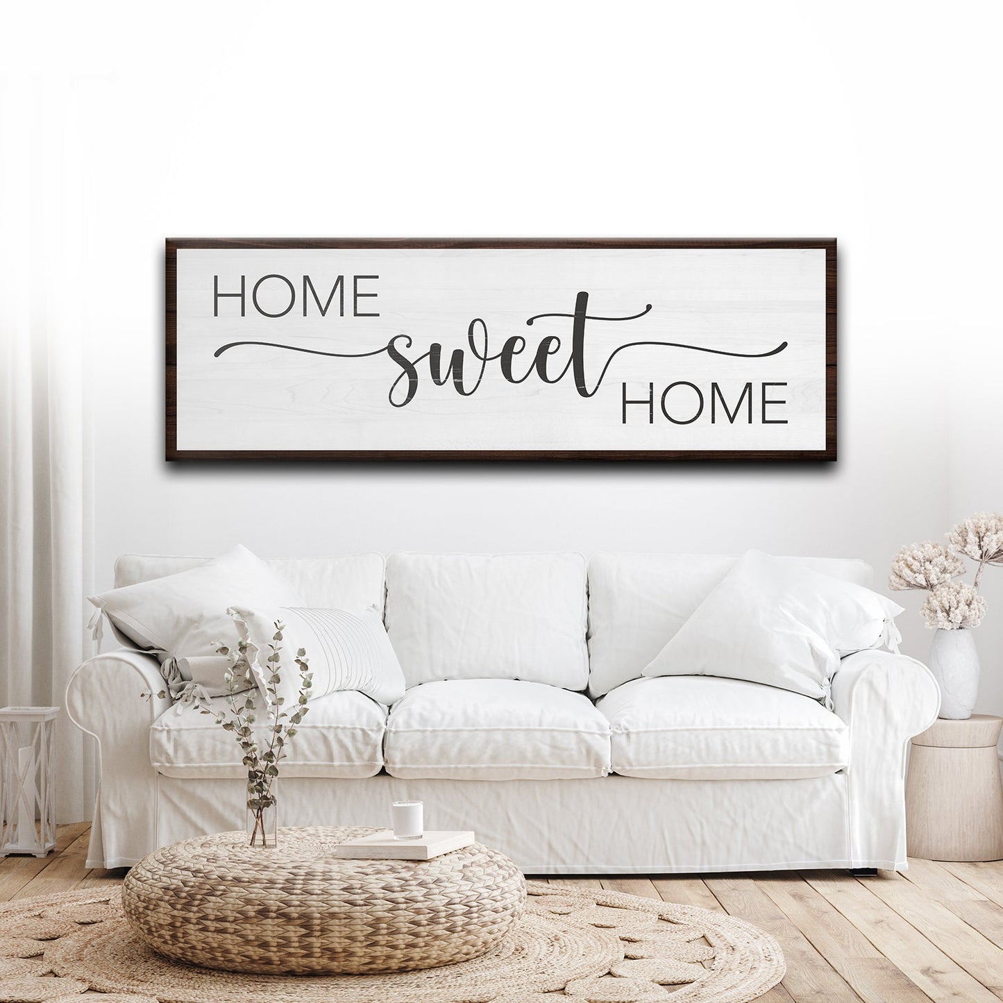 White sofa in a living room with 'Home Sweet Home' framed artwork on the wall.