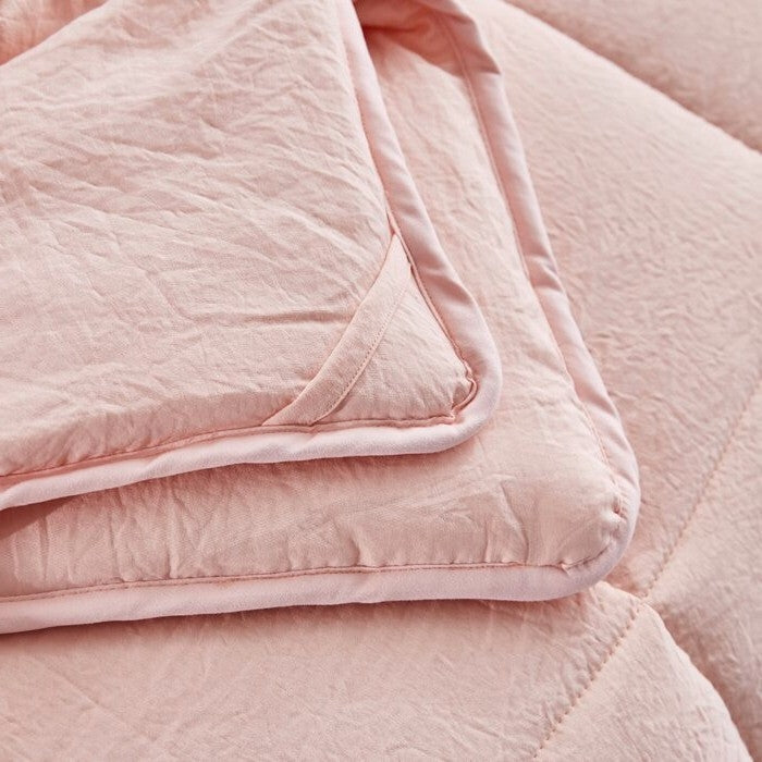 Close-up of a pink quilted blanket with a soft texture.