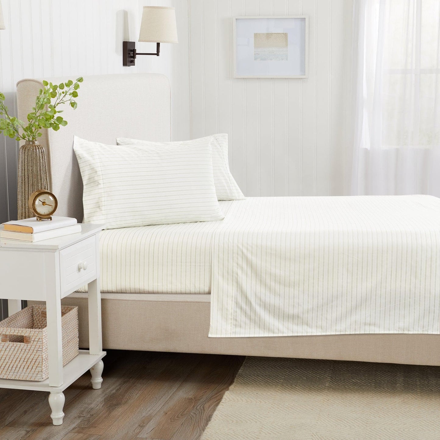 Neatly made bed with white bedding in a bedroom setting.