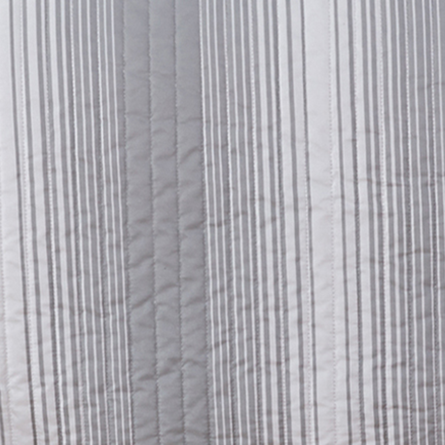 Close-up of gray quilted fabric with subtle pattern