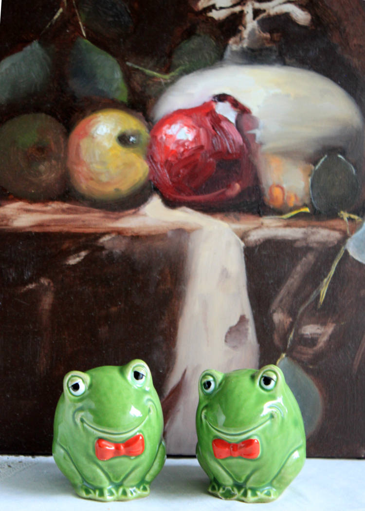 Salt and Pepper Frog Shakers with red bows, hand painted, in front of a fruit still life painting.
