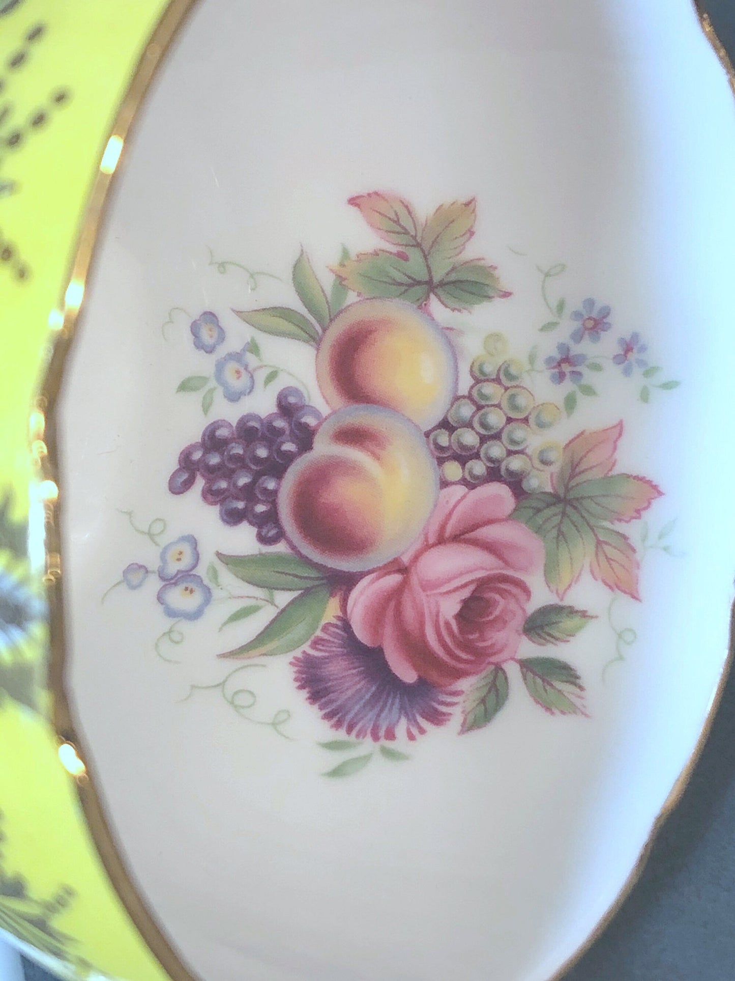 Decorative plate with floral and fruit design on a white background