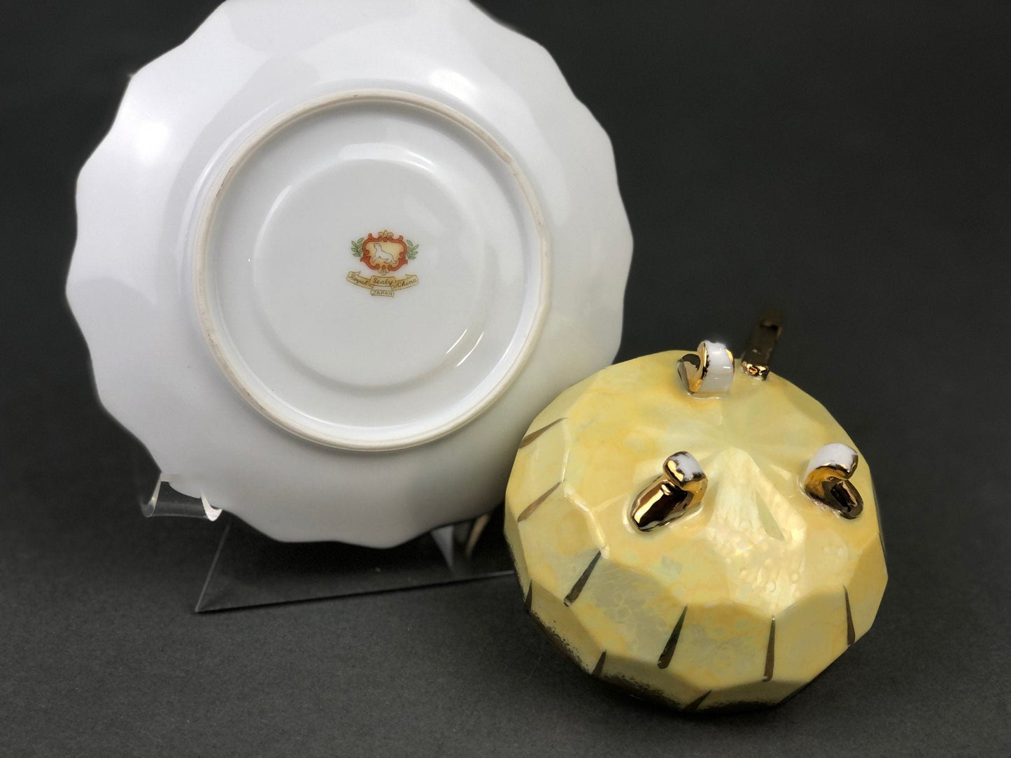 Decorative ceramic cup and saucer with gold accents on a dark background