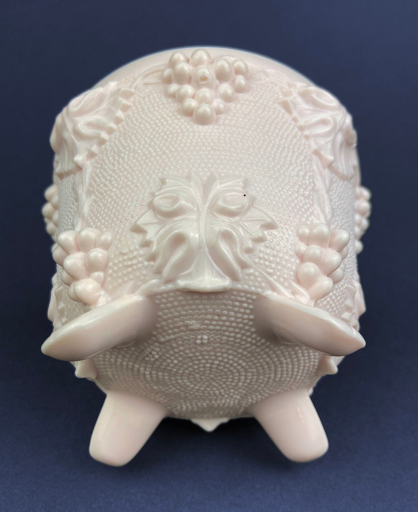Decorative white ceramic jar with intricate patterns on a blue background