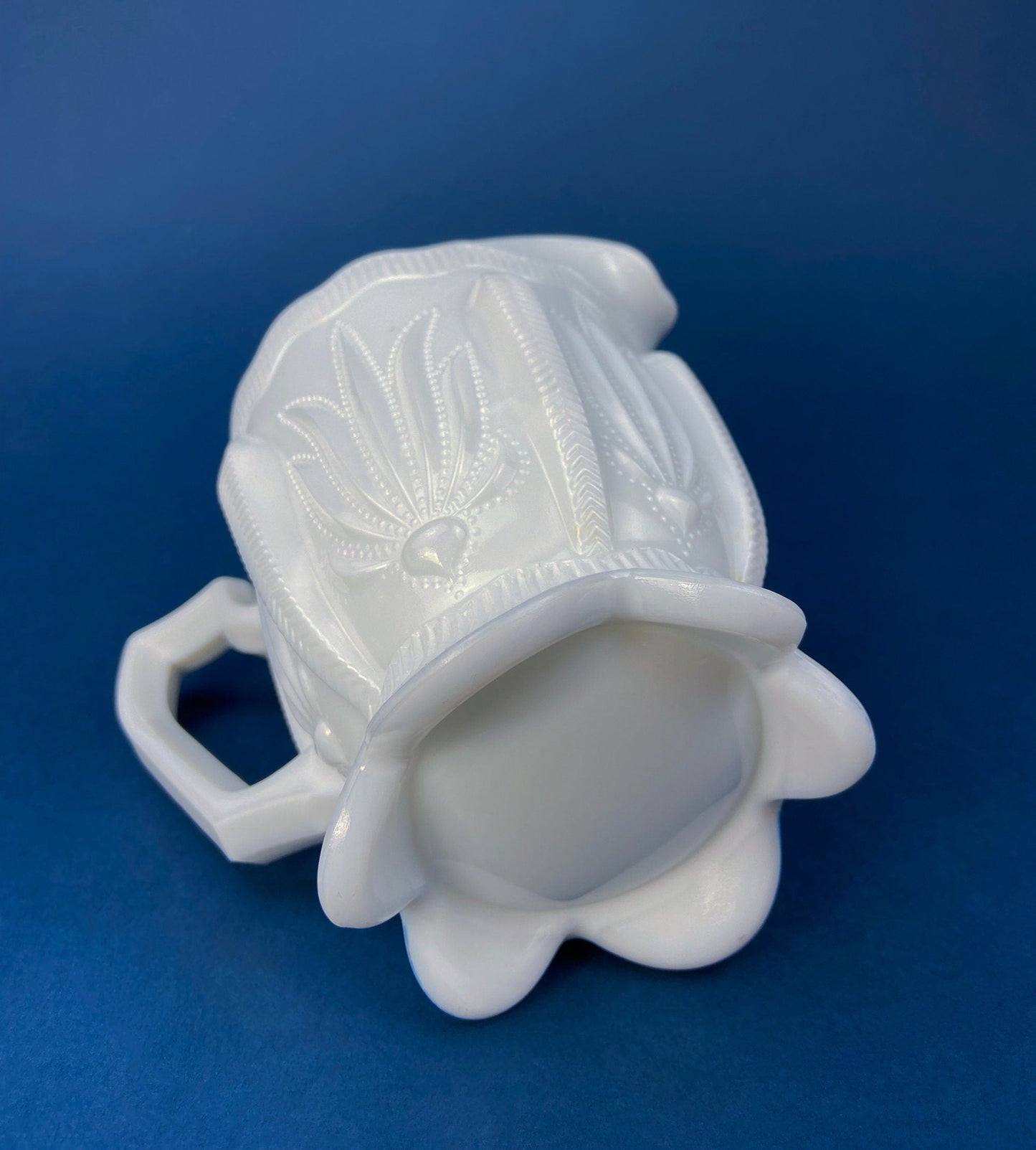White ceramic mug with decorative design on a blue background