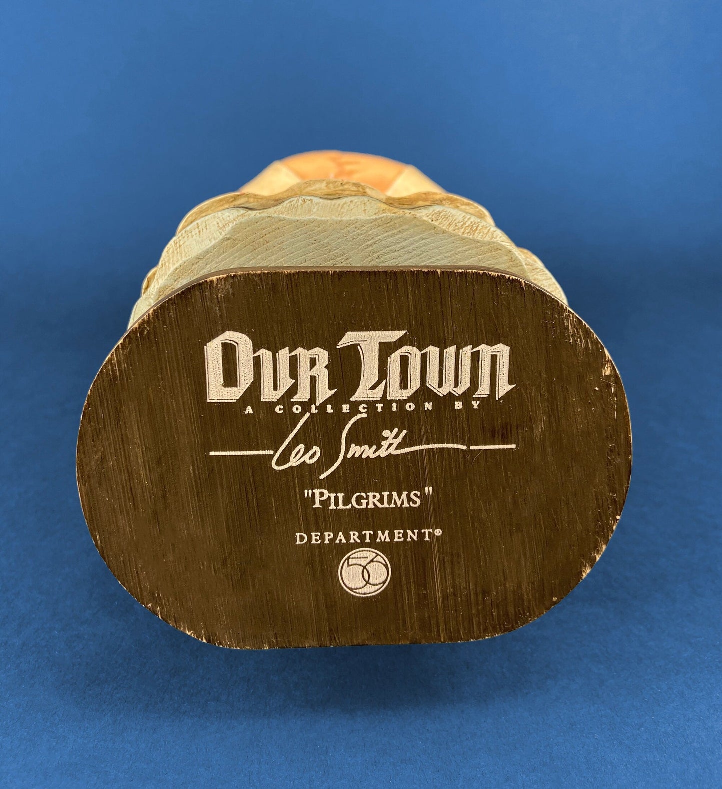 Wooden figurine with 'Our Town' branding on a blue background