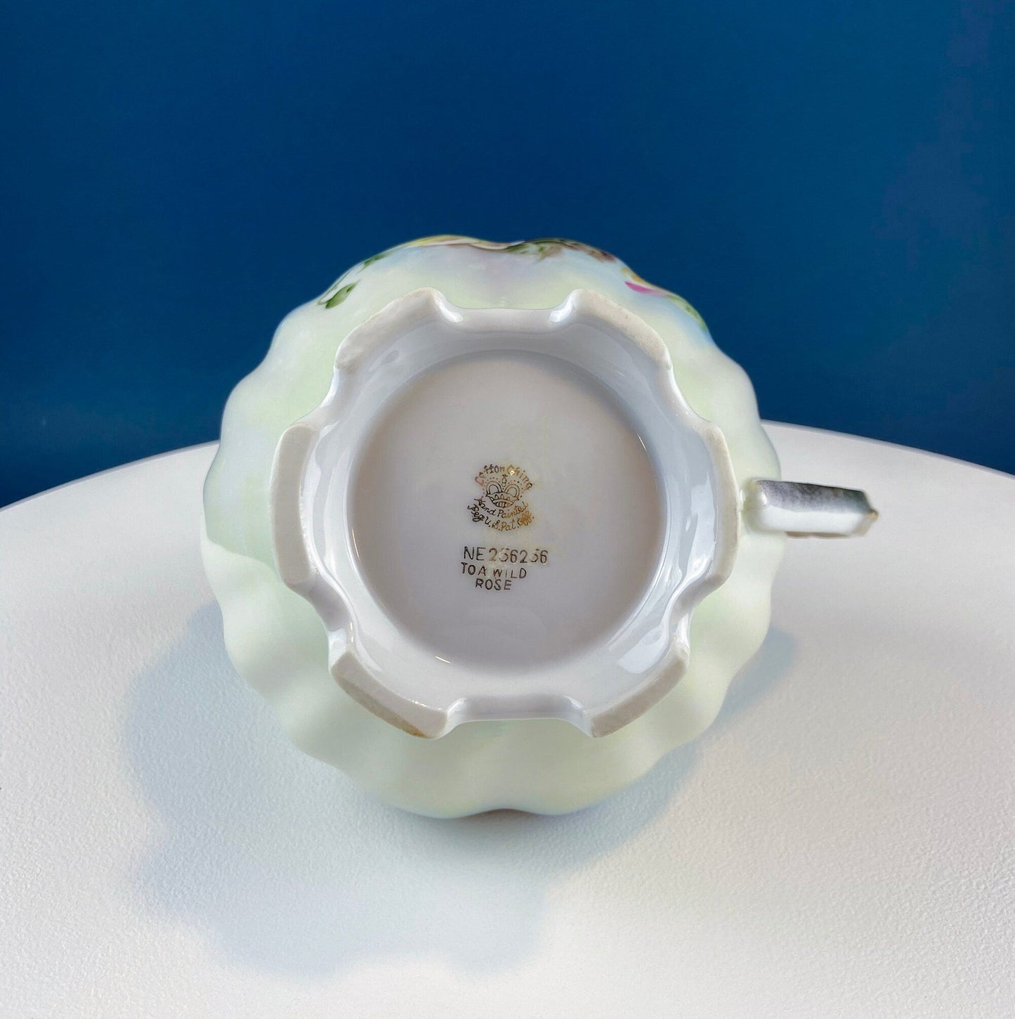 Ceramic item with a visible brand logo on a white surface against a blue background