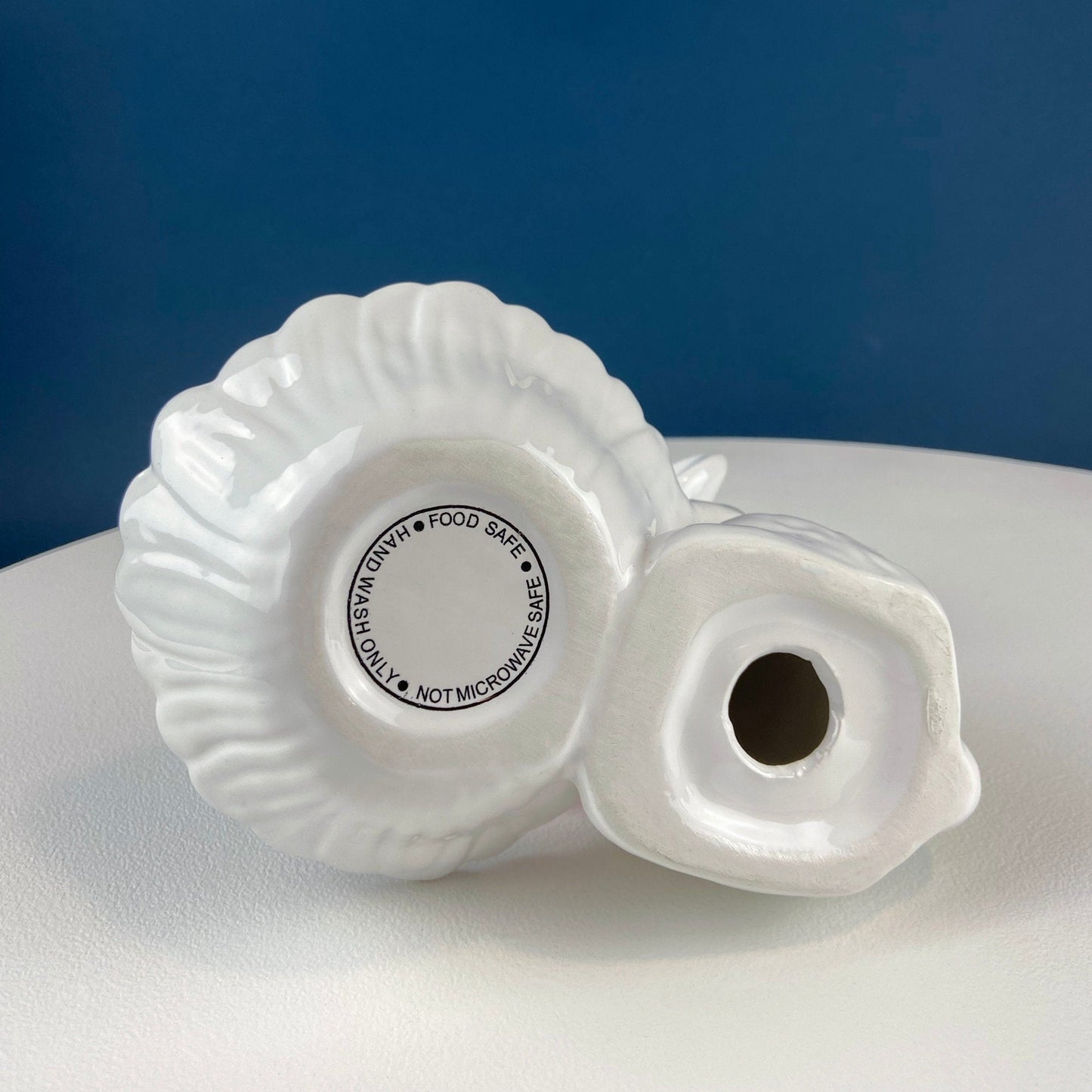 White ceramic bunny on a white surface against a blue background