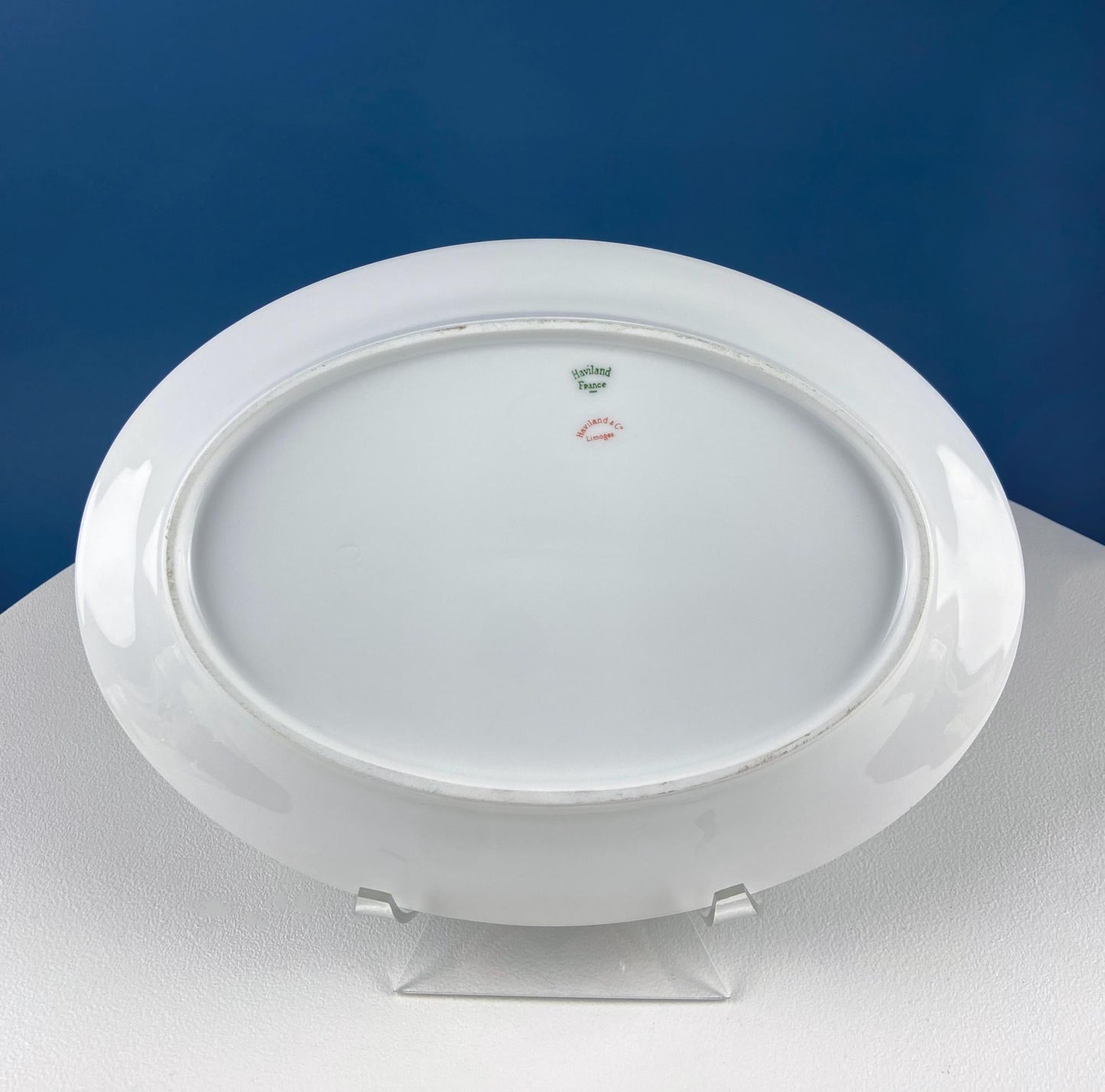 Round white plate on a stand with a blue background