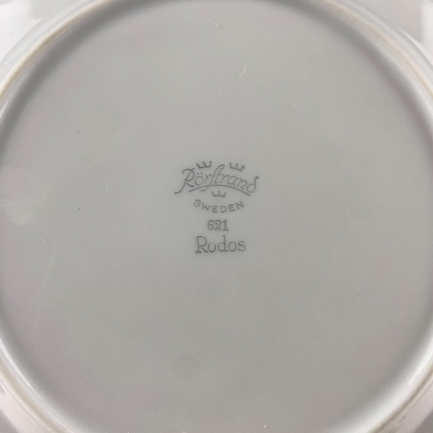 Close-up of a white plate with 'Rorstrand Sweden' branding on a light gray background
