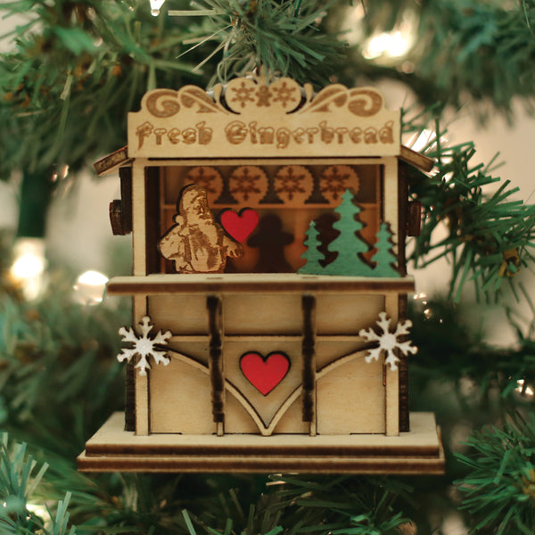 Gingerbread Market Ginger Cottage Collection ornament with trees and gingerbread figures.