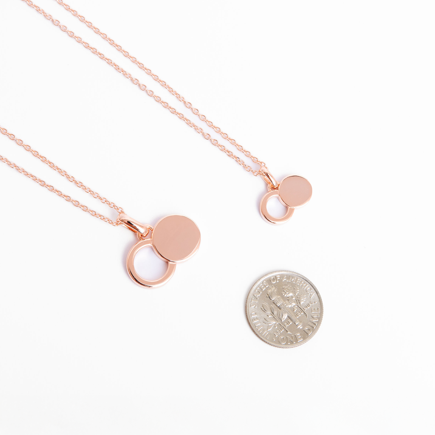 The Empty Tomb Pendant Necklace featured with a quarter for size reference, showcasing its elegant design and symbolism.
