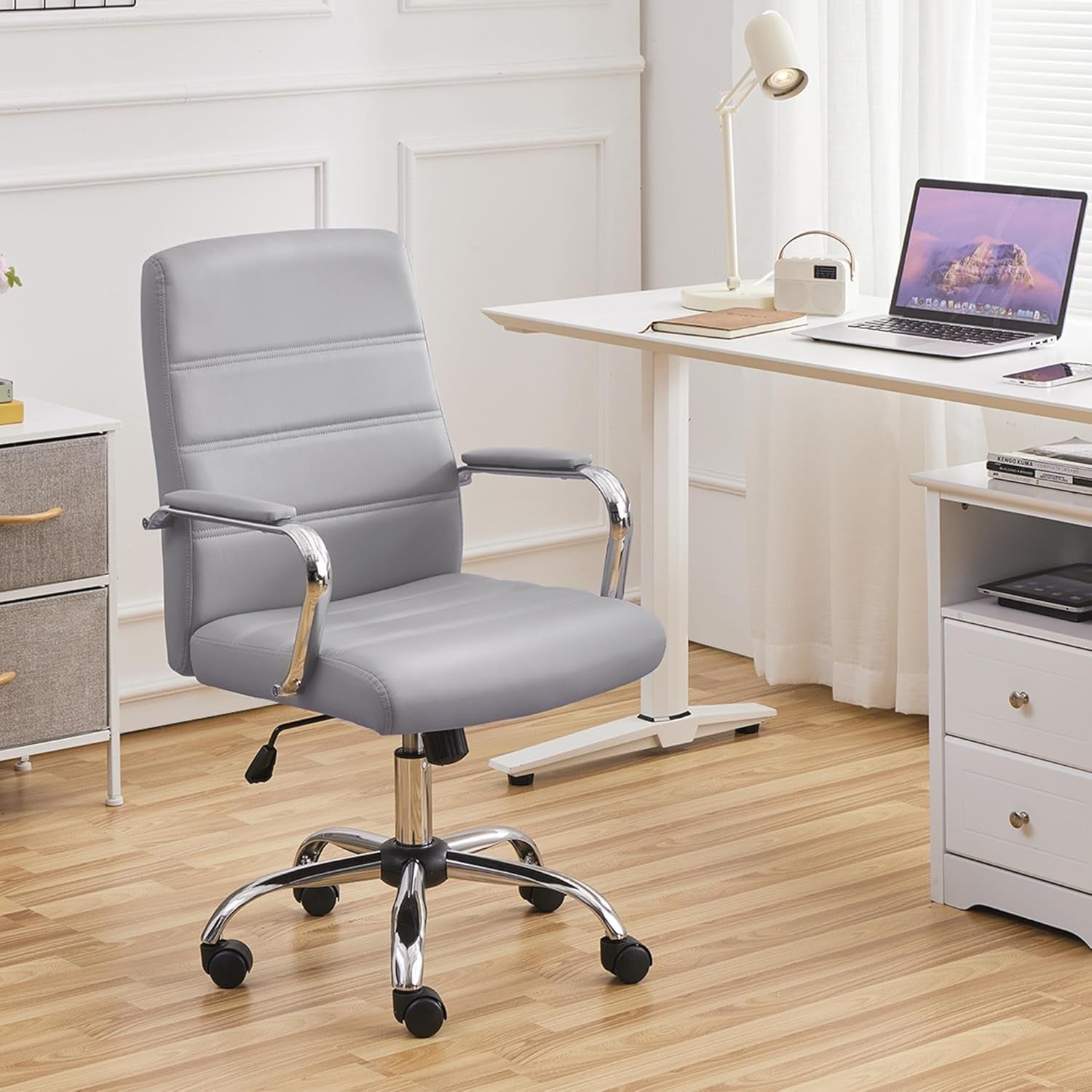 Stylish grey armrest office chair in a modern workspace with a desk and laptop.