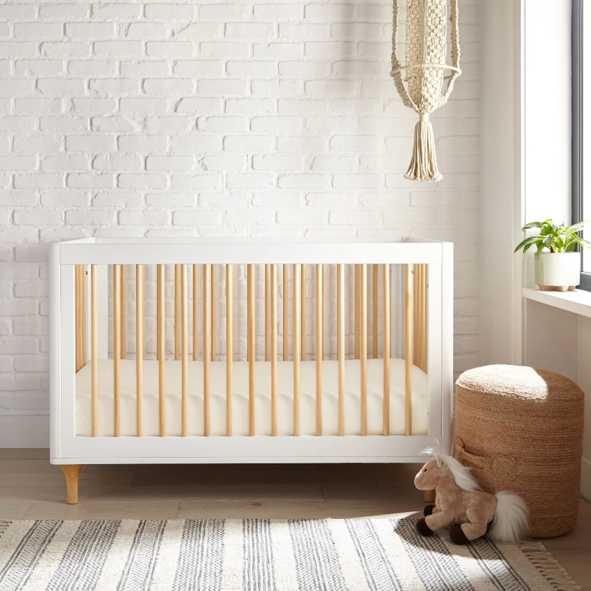 Boho Nursery with a modern crib, a cozy floor, and a playful stuffed animal in a warm and inviting setting.