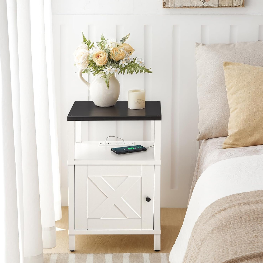 Smart Nightstands with a black top, white cabinet, vase of flowers, and a phone charging on the surface.