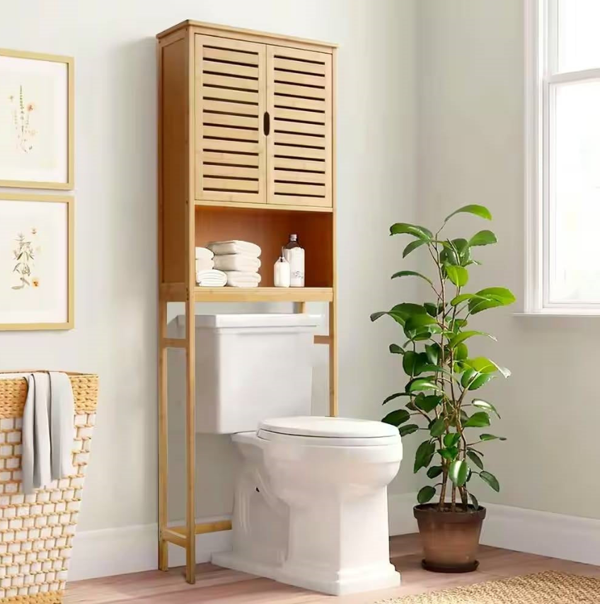 Mission Bathroom featuring a wooden storage cabinet above a toilet with towels and a plant in a well-lit setting.