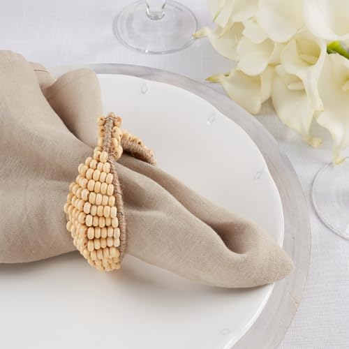 Cloth Napkins elegantly folded with a decorative napkin ring on a white plate, surrounded by beautiful flowers.