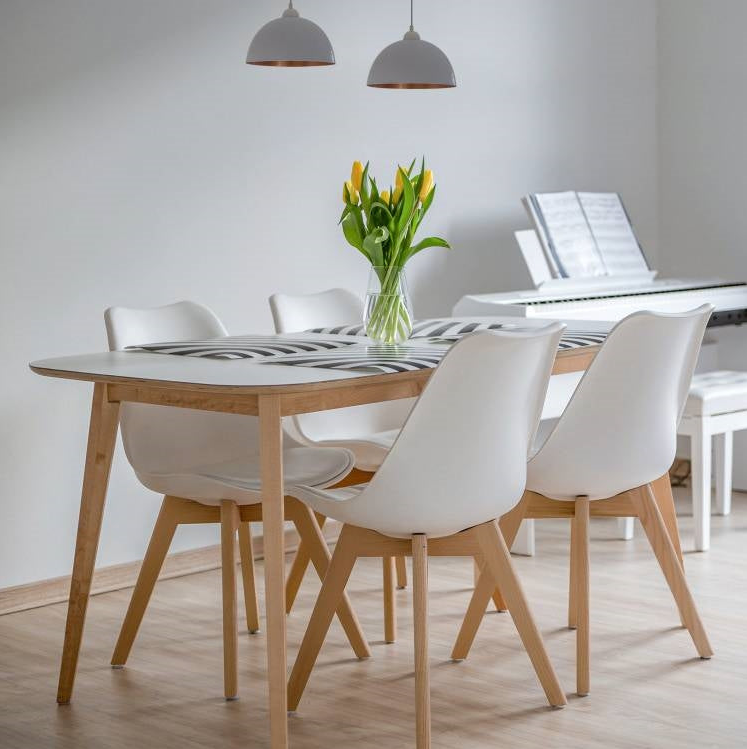 Modern dining table set with white chairs and a vase of tulips in a Mid-Century Modern Dining Room.