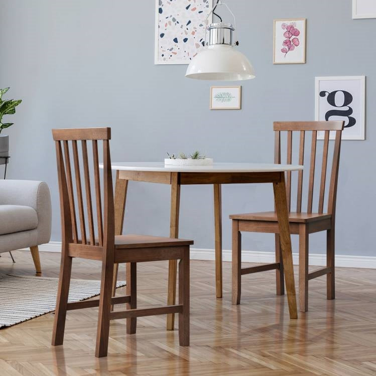 Mission Dining Room featuring a round table and two wooden chairs against a stylish backdrop.