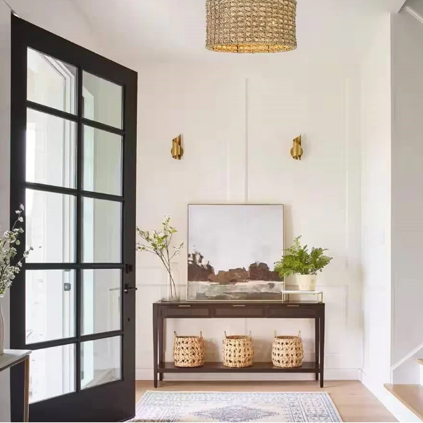 Stylish Boho Foyer featuring a black door, woven baskets, and elegant artwork.