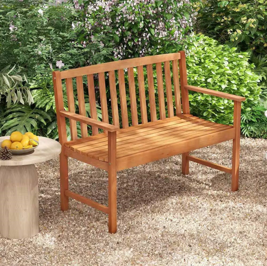 A wooden bench surrounded by green foliage in the Mission Garden collection.