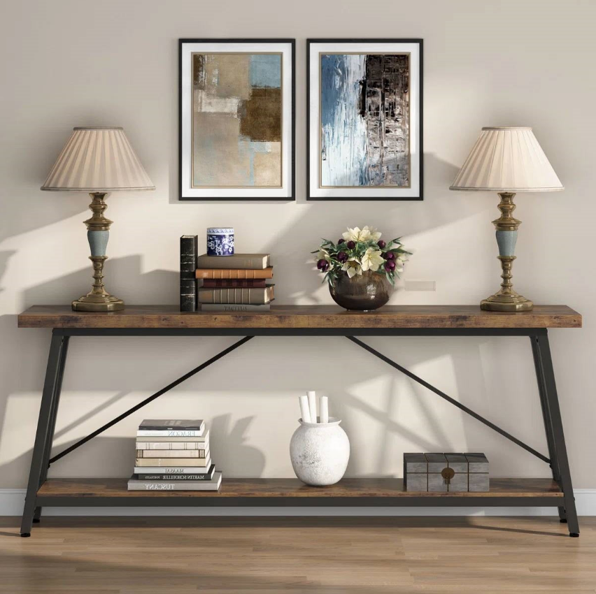 Stylish industrial foyer featuring a wooden console table, lamps, artwork, and decorative elements.
