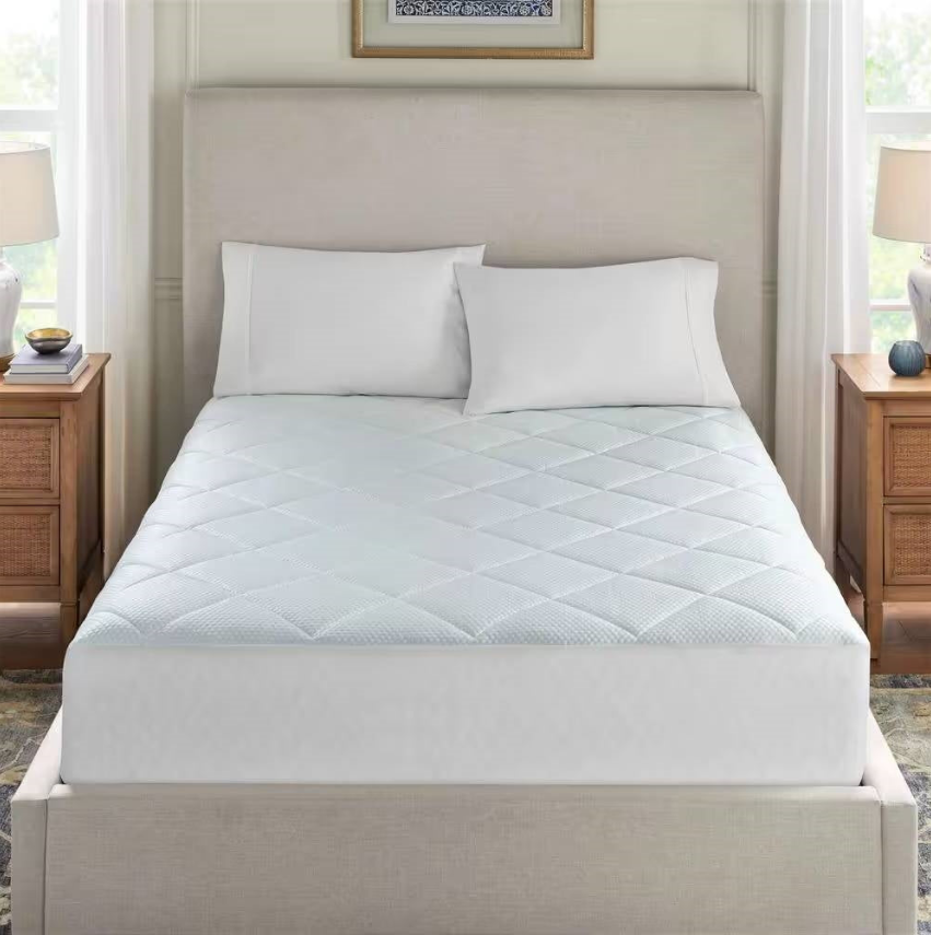 Mattress Toppers on a bed with white pillows and soft quilted design, enhancing comfort and protection.