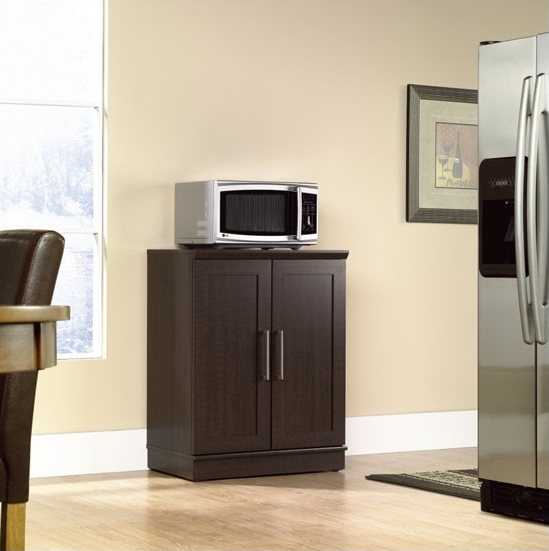 Contemporary Kitchen featuring a microwave on a wooden cabinet next to a stainless steel refrigerator.