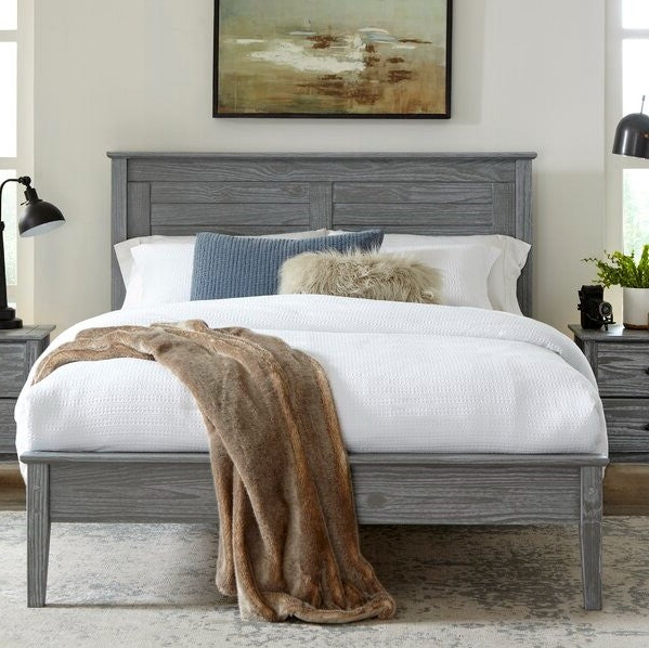 Contemporary Bedroom featuring a gray wooden bed with white bedding and decorative throw.