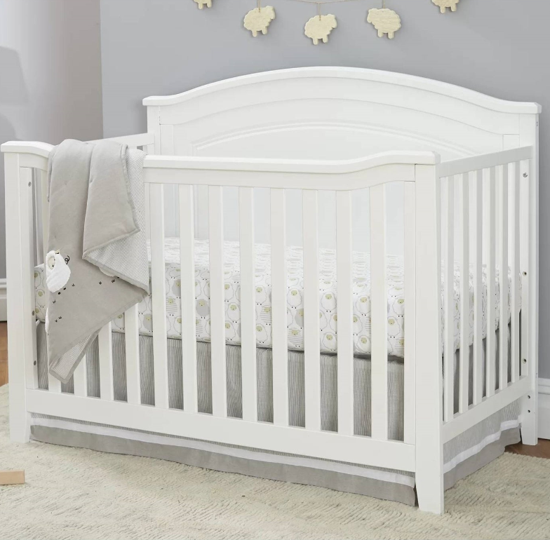 A white crib with a soft blanket in a nursery, part of the Mission Nursery collection.
