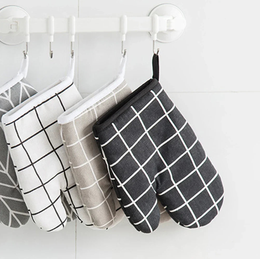 Stylish Oven Mitts and Potholders hanging on a rack, perfect for kitchen use.