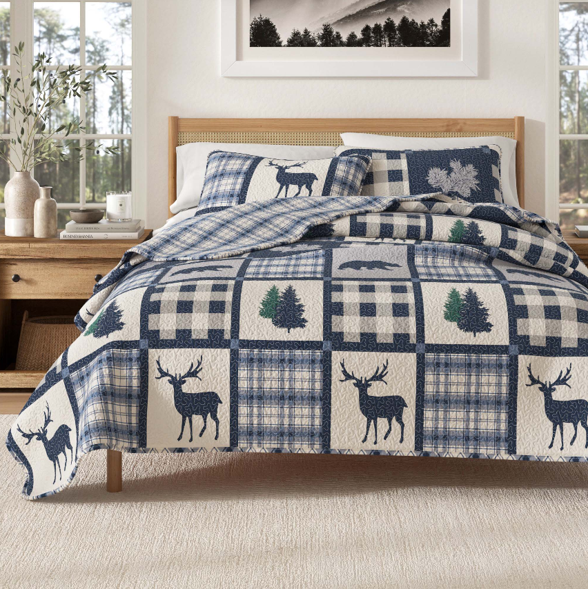 Rustic Bedroom featuring a cozy quilt with deer and pine tree patterns on a warm wooden bed frame.