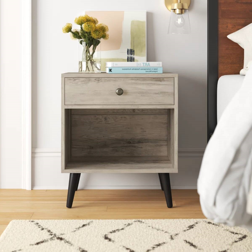 Mid-Century Modern Bedroom nightstand with drawer, decor, and floral arrangement beside a bed.