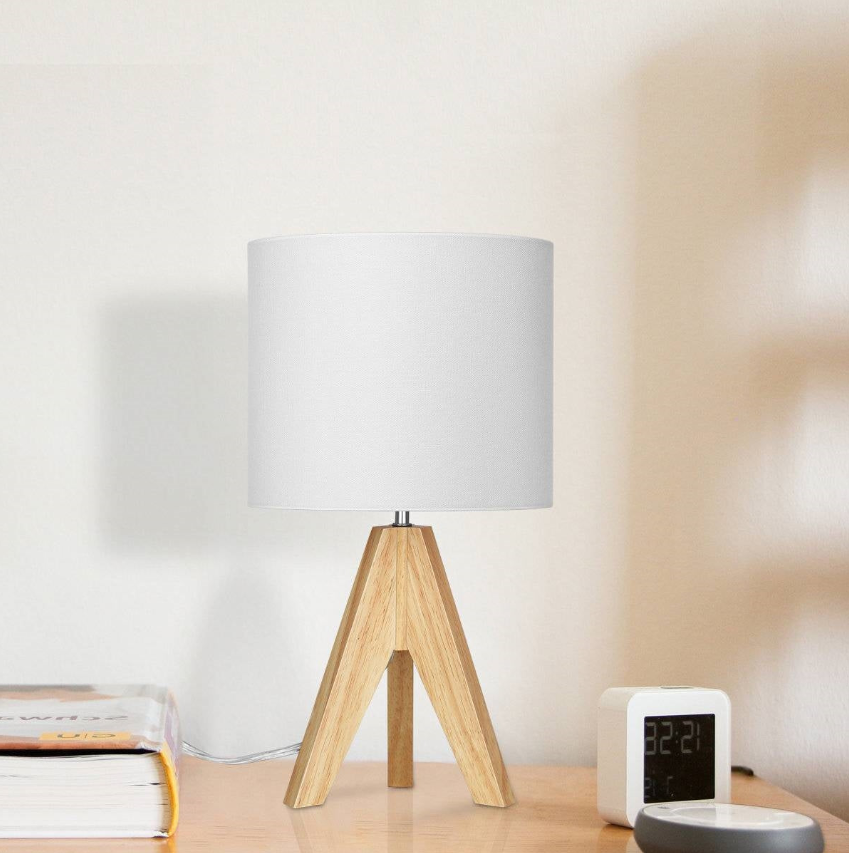 Wooden tripod lamp with white shade in a Scandinavian Nursery setting.