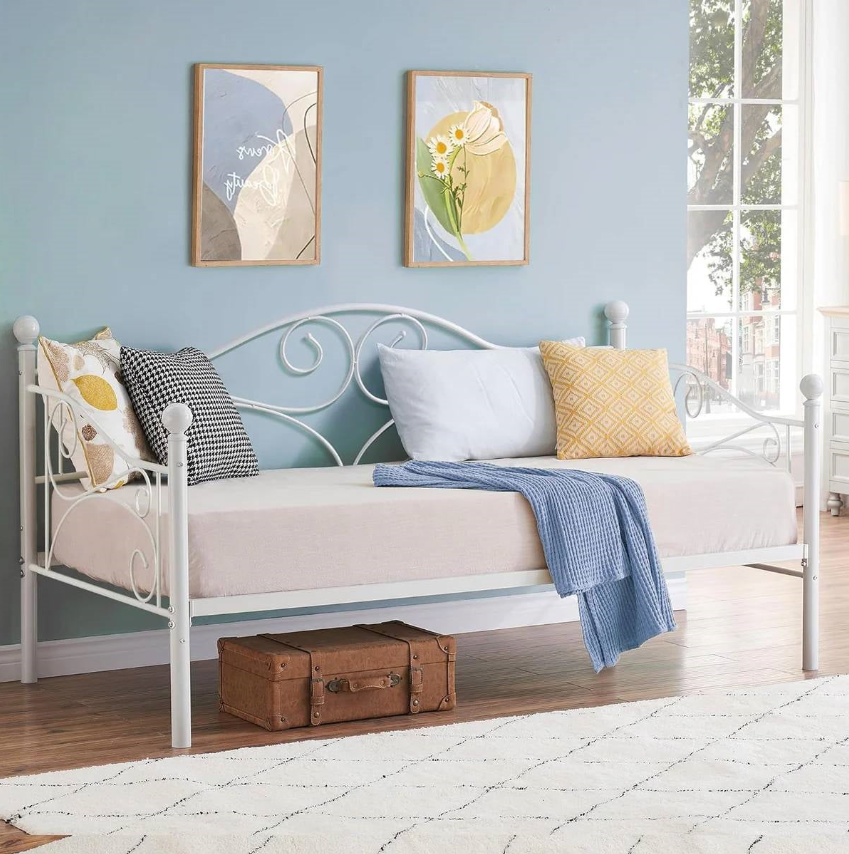 A stylish daybed in a Classic Kids' Bedroom with decorative pillows and wall art.