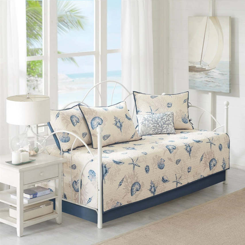 Coastal Living Room featuring a daybed with seashell patterns, blue accents, and a bright, airy setting.