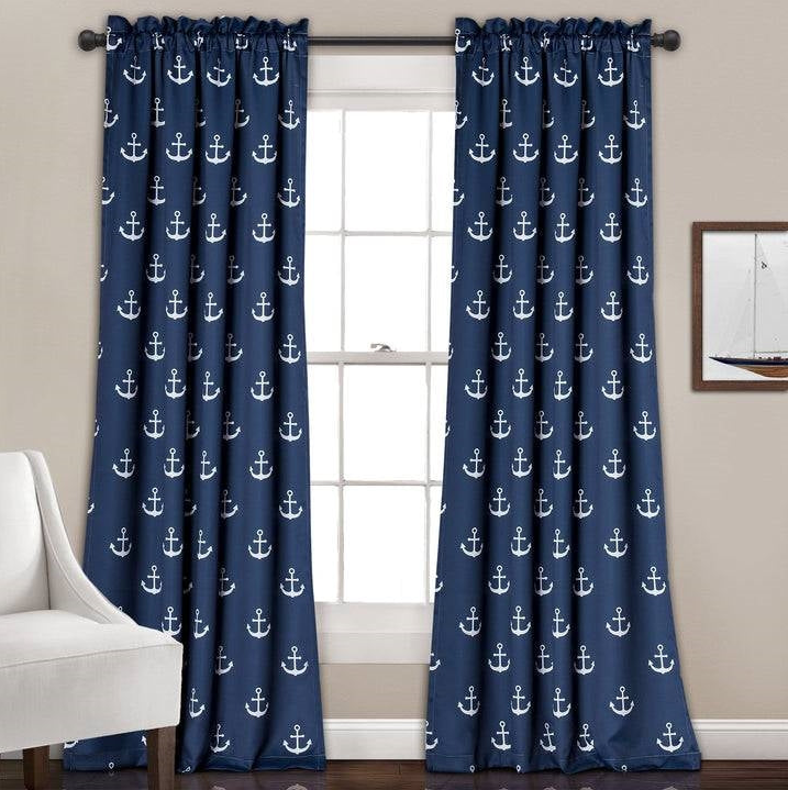 Coastal Home Office with navy anchor-patterned curtains framing a bright window and cozy chair.