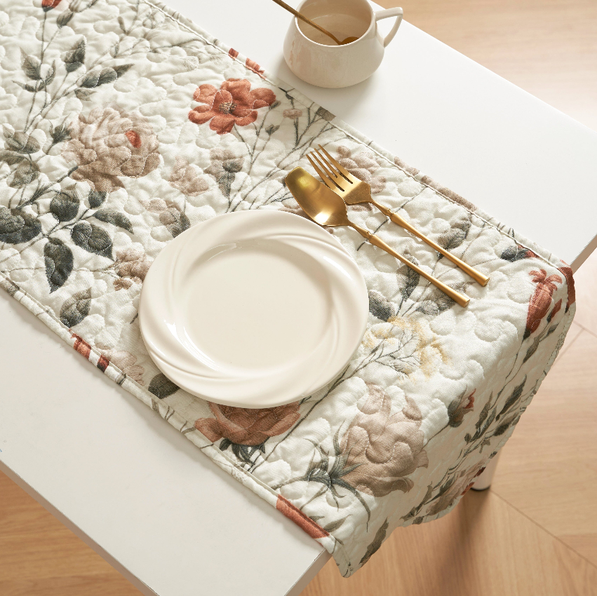 Elegant floral table runner displayed on a table with a plate and golden cutlery, perfect for stylish dining. Table Runners.