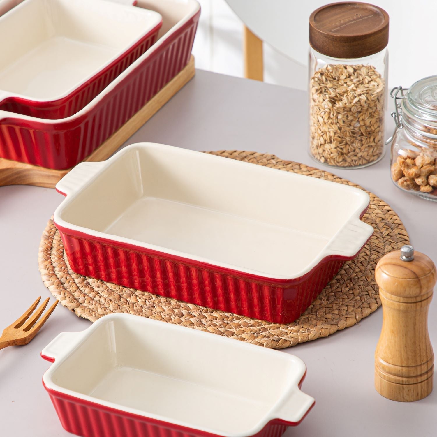 Casserole Dishes arranged on a table, featuring red ceramic casserole dishes with a beige interior.