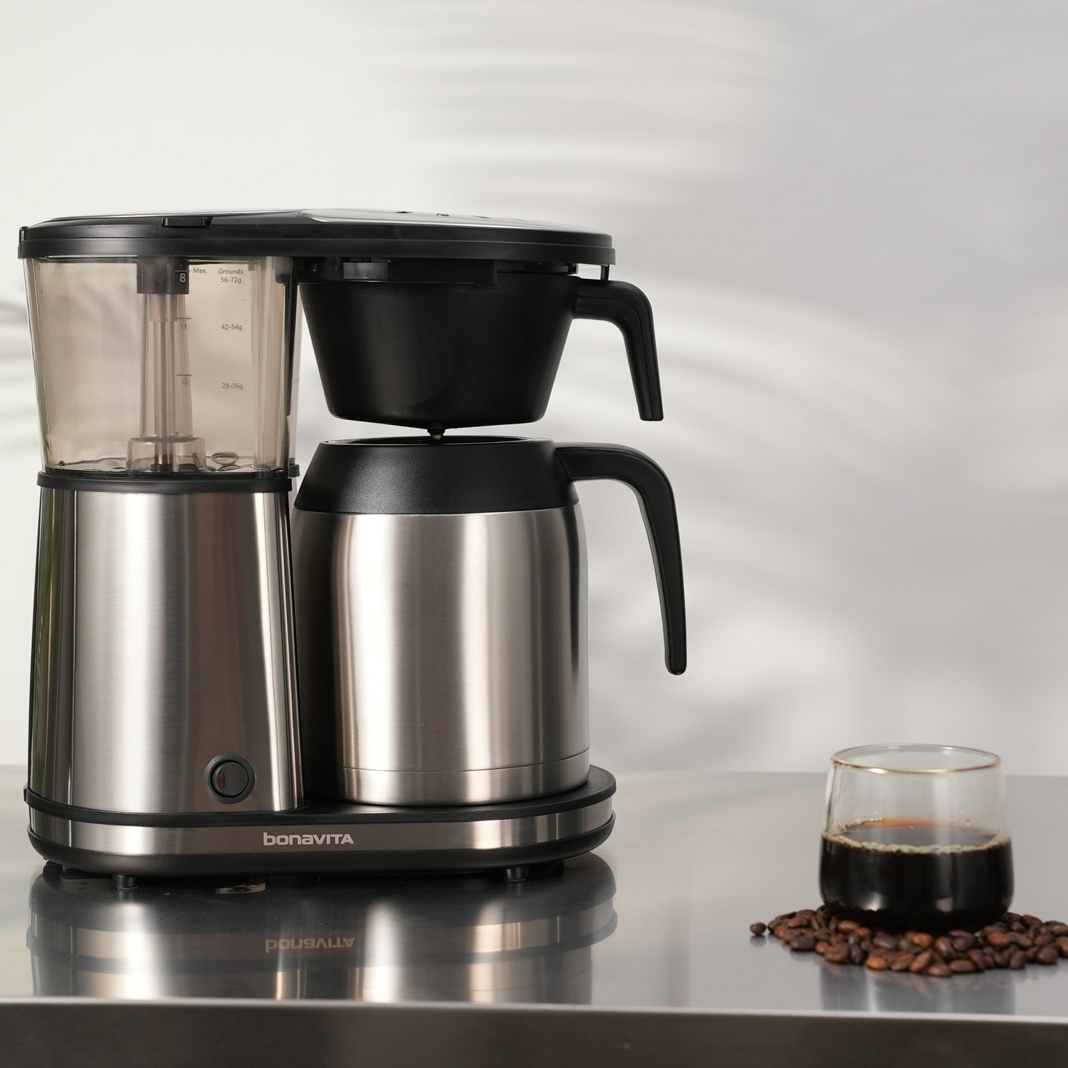 Bonavita coffee maker with stainless steel carafe and brewed coffee glass on a table, featuring Coffee Makers.