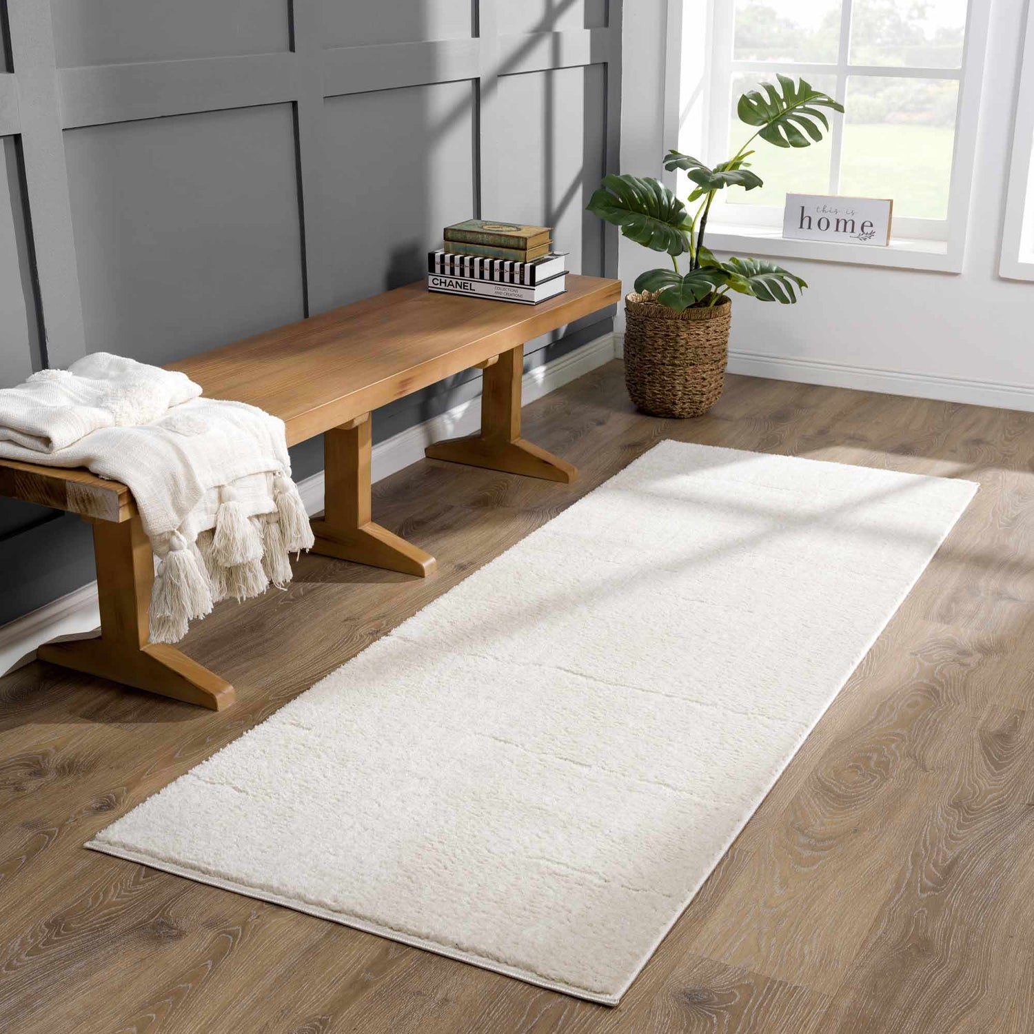 Elegant Runner Rugs on wooden floor beside a cozy bench with a blanket and plant in a well-lit room.
