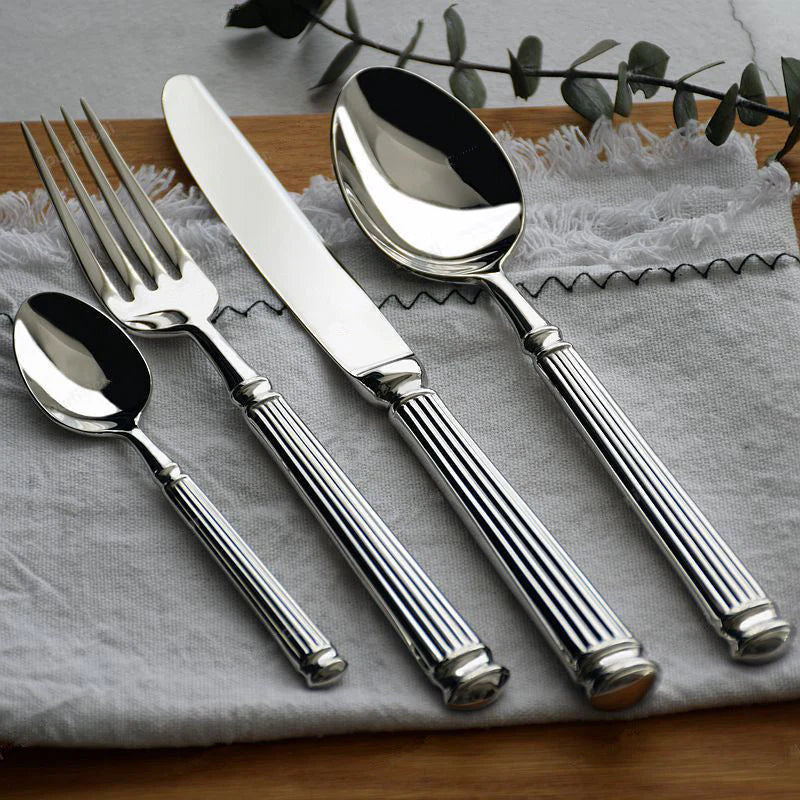 Elegant Flatware Sets featuring a fork, knife, tablespoon, and teaspoon on a textured linen backdrop.