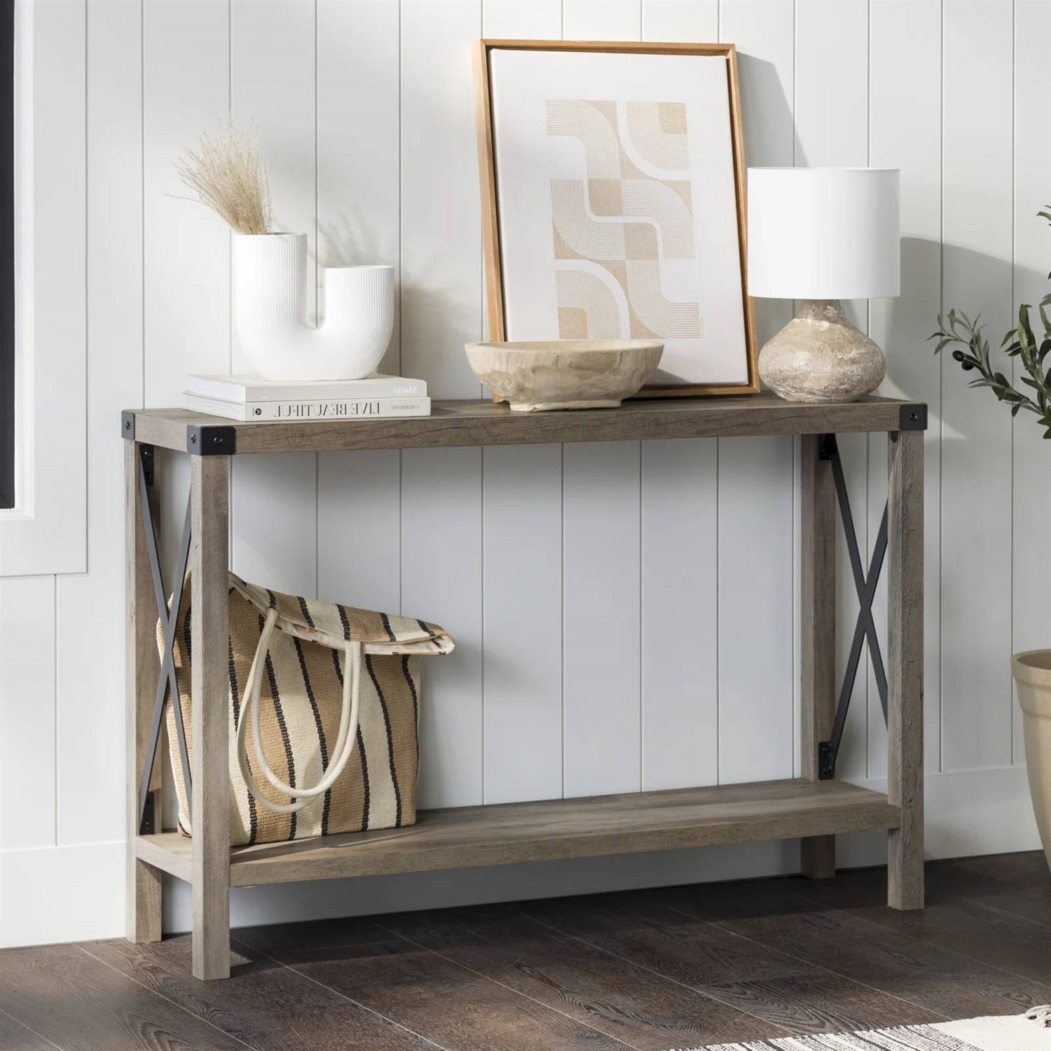 Farmhouse Foyer console table with decorative items and a lamp against a white wall.