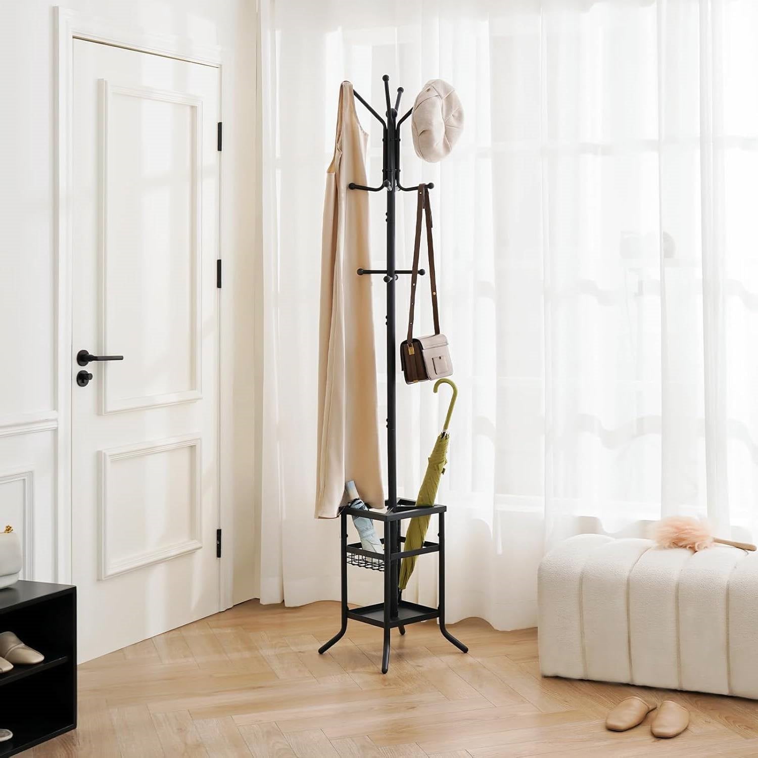 Stylish standing coat rack in a bright room with a curtain and accessories hanging.